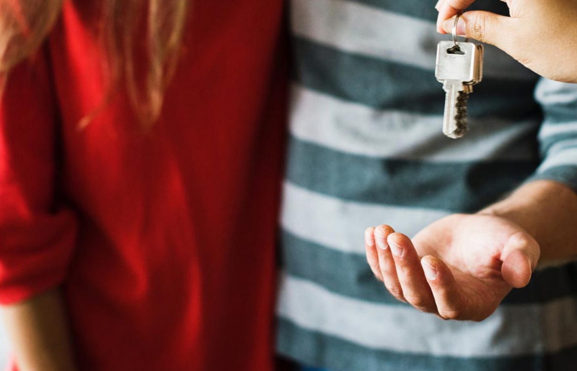 Closeup of someone holding keys over another person’s hands.