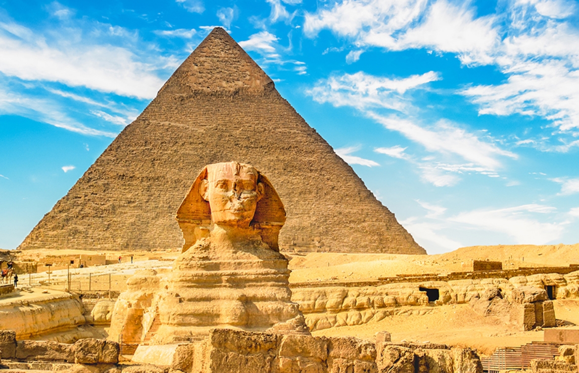 Front view of the Sphynx in Egypt with a pyramid in the background.