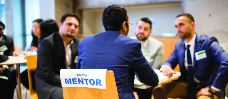 Four people sitting around a table participating at an Alumni Mentor event.