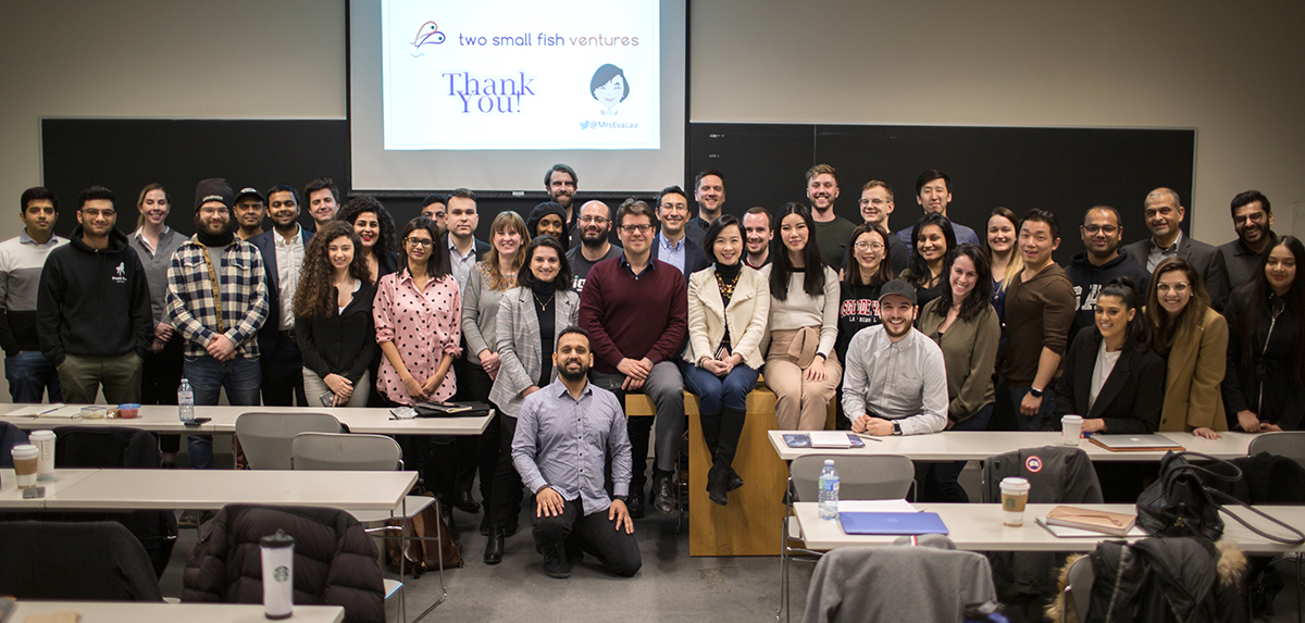 Large group photo from an alumni and student event, pictured in a Schulich classroom.