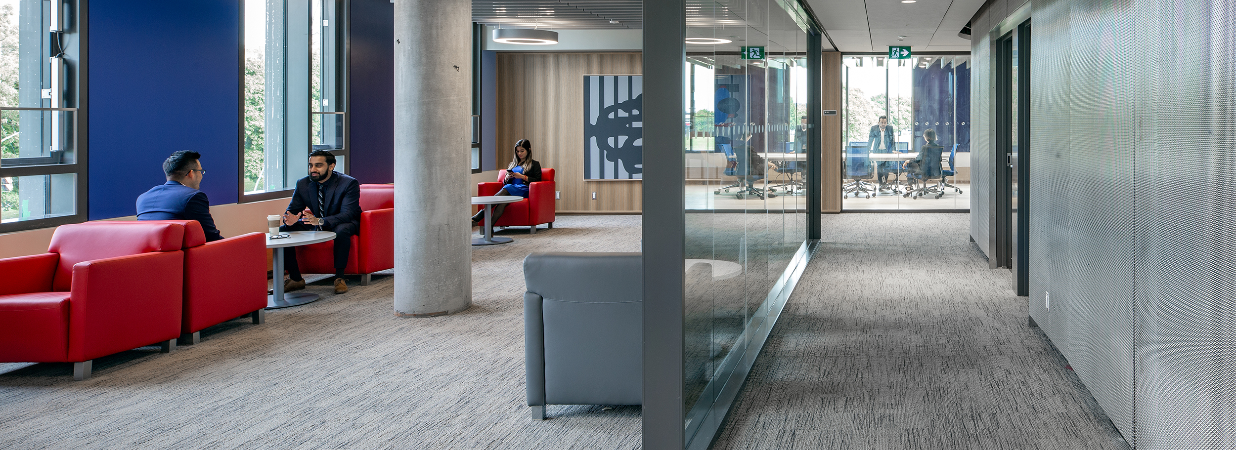 Wide angle view of a lounge and boardroom within the Rob and Cheryl McEwen Graduate Study & Research Building.