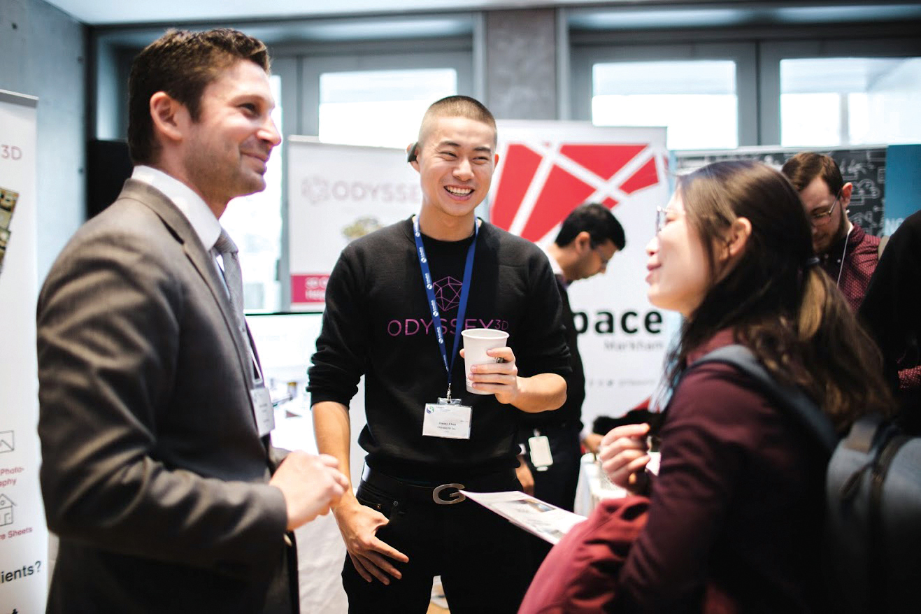 Three people in conversation at a networking event.