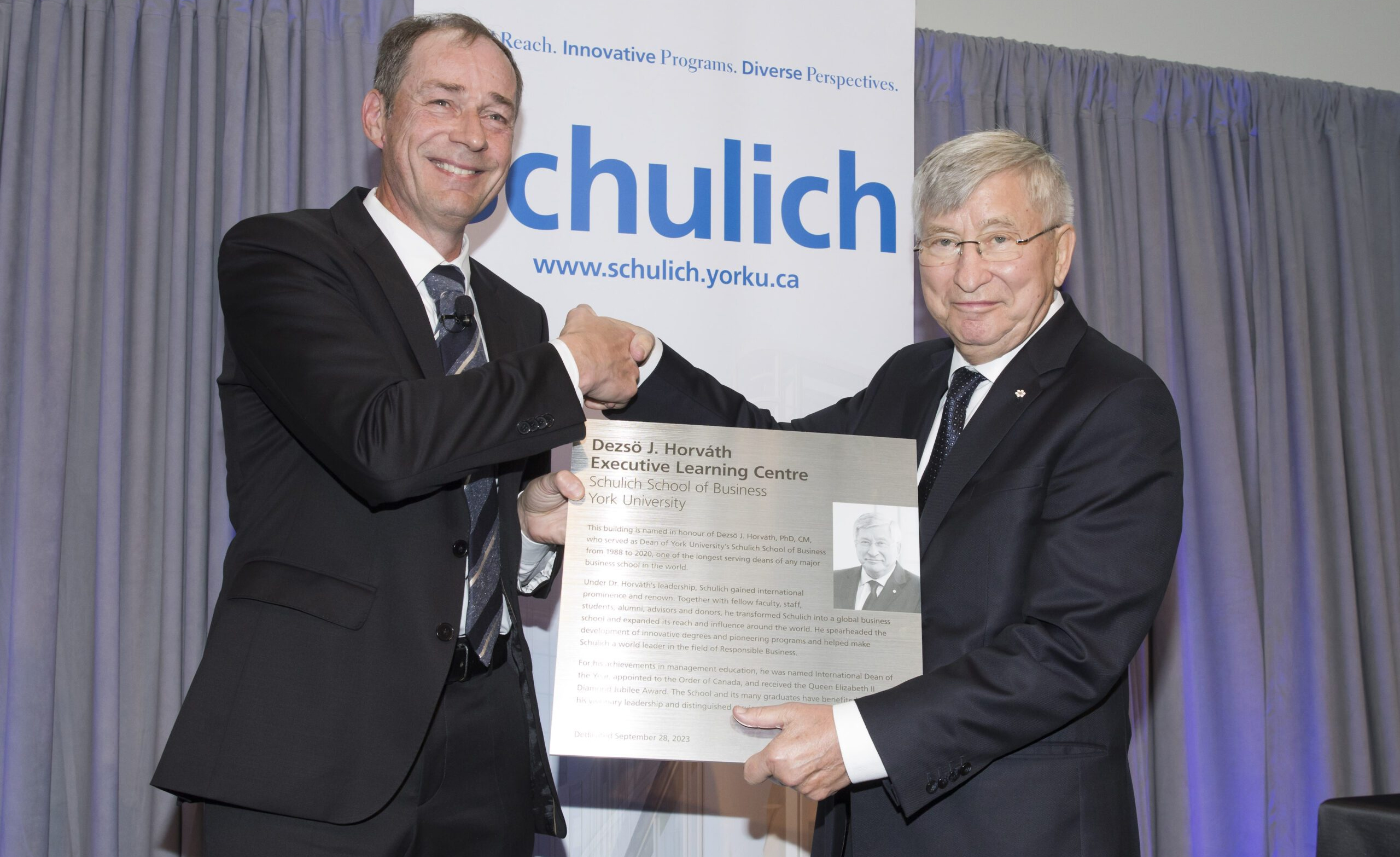 Dean Detlev Zwick presenting Dean Emeritus Dezsö Horváth with a plaque in recognition of the honorific naming.